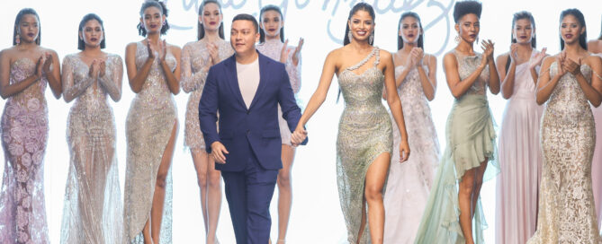 Desfile de moda en el DBA Fashion Show con modelos en vestidos de gala y diseñador en pasarela.