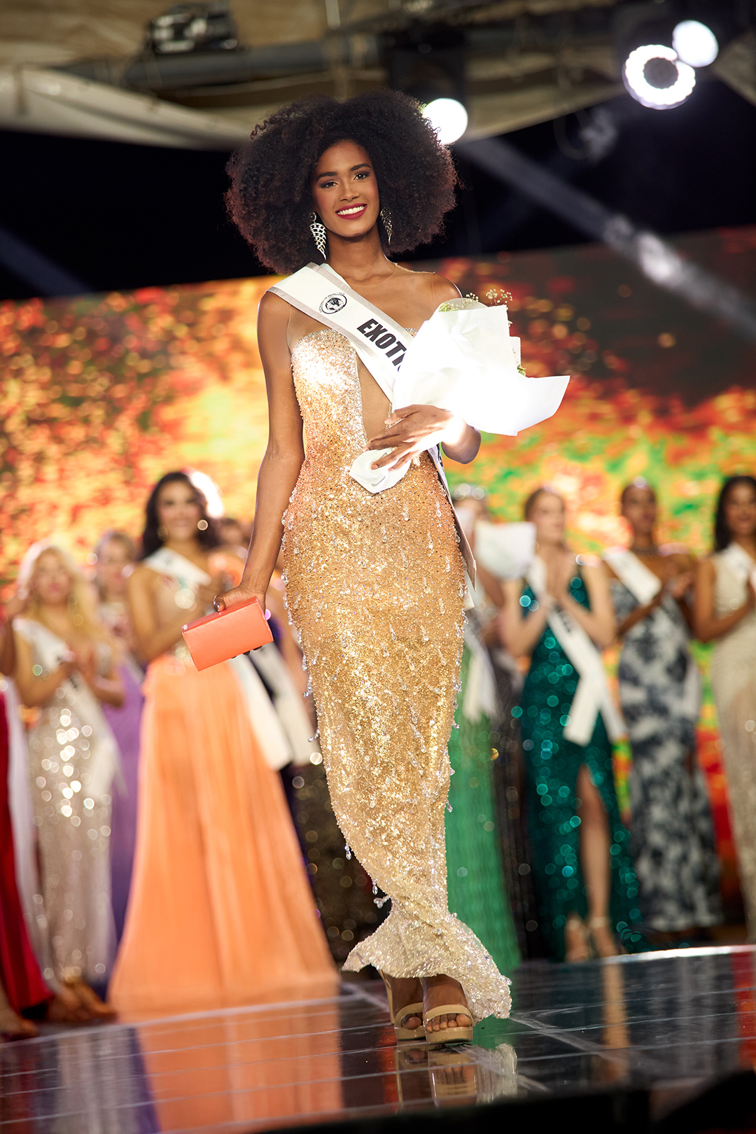 Smarling Mañón, modelo dominicana de DBA, desfila en el escenario con flores y premio en el Top Model of the World 2025 en Egipto.