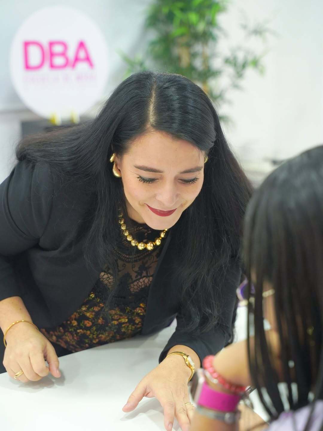 Facilitadora del curso de Ilustración de Moda en DBA orientando de forma cercana a una estudiante.