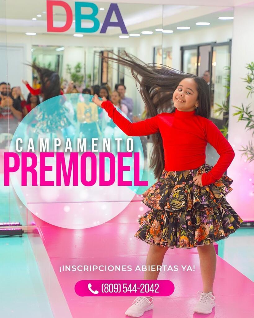 Seguridad y alegría en cada paso: Campamento Premodel DBA Niña sonriendo mientras camina con seguridad en pasarela durante el Campamento Premodel de DBA, vistiendo falda floral y blusa roja, en un salón con público de fondo.